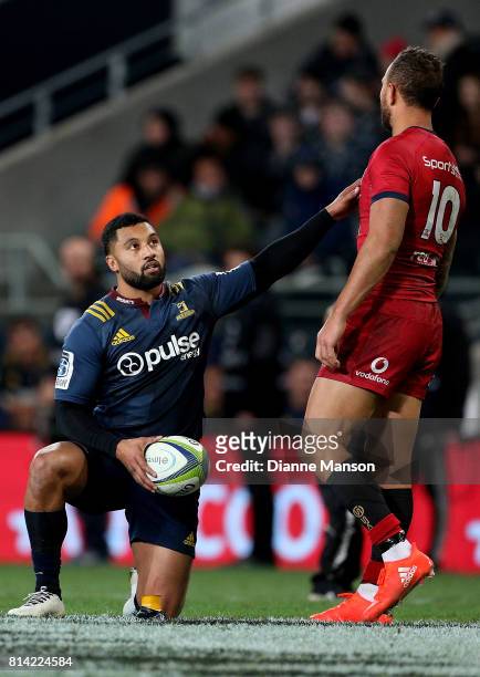 Lima Sopoaga of the Highlanders is appraoched by Quade Cooper of the Reds as he lines up a conversion during the round 17 Super Rugby match between...