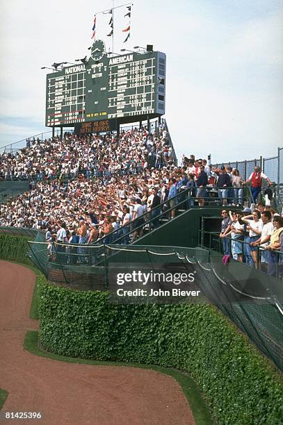 Baseball: View of Chicago Cubs fans in stands at Wrigley Field, stadium during game vs Colorado Rockies, View of scoreboard and ivy, Chicago, IL...