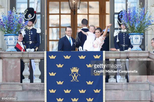 Crown Princess Victoria of Sweden, Princess Estelle of Sweden and Prince Daniel of Sweden wave to fans waiting outside the Royal Palace for Princess...