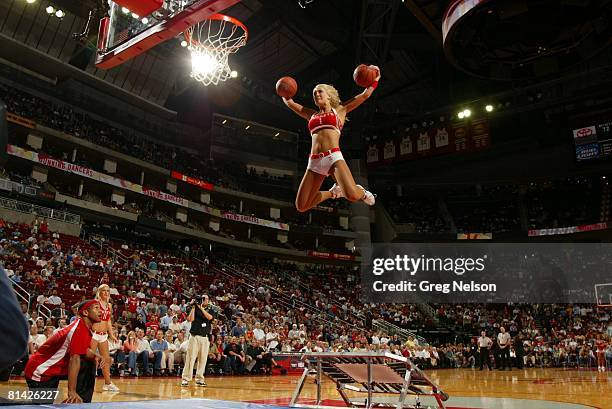 Basketball: Houston Rockets dance team cheerleader making dunk from trampoline during game vs Indiana Pacers, Houston, TX 3/20/2007