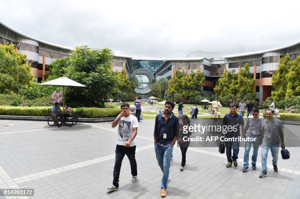 Employees of Indian Software giant Infosys Technologies Limited walk in the campus of the company's headquarters in Bangalore on July 14, 2017. / AFP...