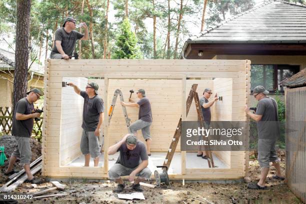 multiple exposures of man building wooden shack - creepy shack stock pictures, royalty-free photos & images