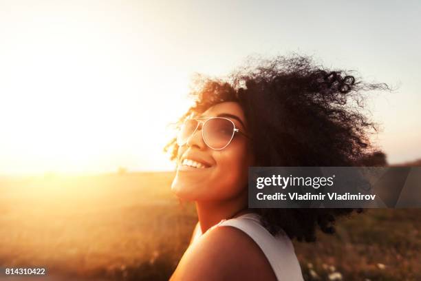 giovane donna che si diverte al tramonto - smiling controluce foto e immagini stock