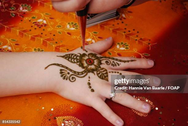 artist applying henna on women's hand - hannie van baarle stock pictures, royalty-free photos & images