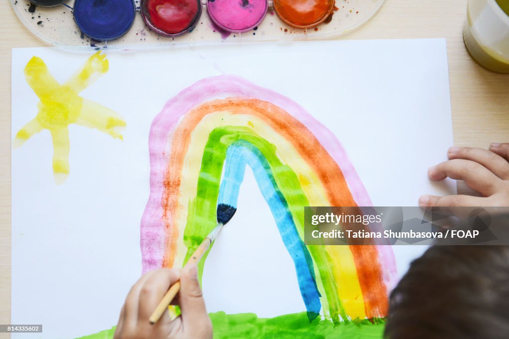 Child drawing rainbow
