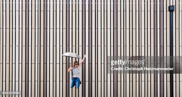 jumping woman with open umbrella - woman full frame stock pictures, royalty-free photos & images