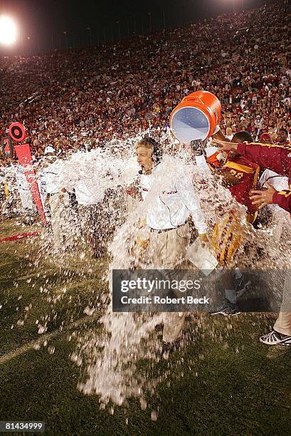 College Football: USC victorious, pouring Gatorade water bucket on coach Pete Carroll after winning game vs UCLA, Los Angeles, CA 12/3/2005