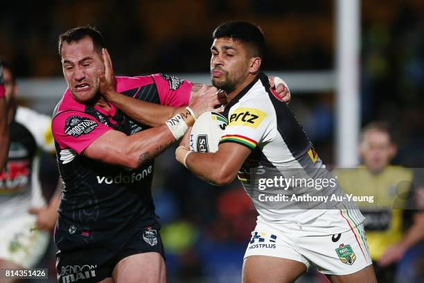 Tyrone Peachey of the Panthers fends against Bodene Thompson of the Warriors during the round 19 NRL match between the New Zealand Warriors and the...