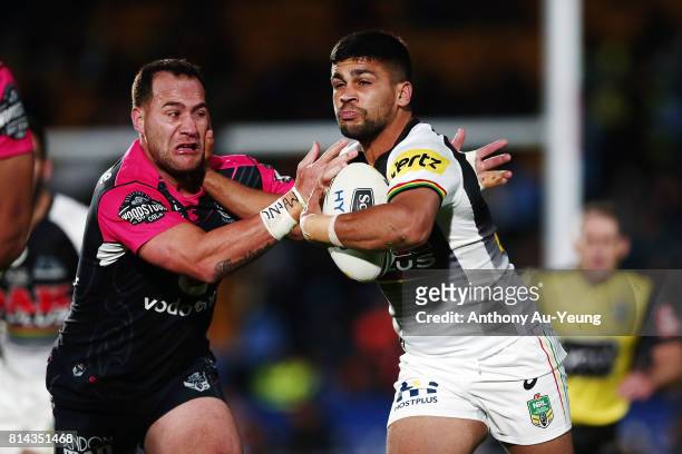 Tyrone Peachey of the Panthers fends against Bodene Thompson of the Warriors during the round 19 NRL match between the New Zealand Warriors and the...