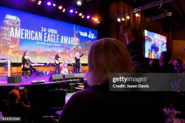 Artie Kornfeld, Music Promoter for Woodstock Festival, pumps his fist as Recording Artist Patti Smith performs during the American Eagle Awards...