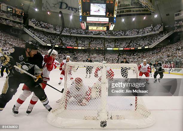 Marian Hossa of the Pittsburgh Penguins slides the puck through the crease pass goaltender Chris Osgood of the Detroit Red Wings in the final seconds...