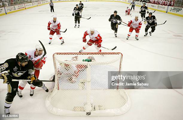 Marian Hossa of the Pittsburgh Penguins slides the puck through the crease past goaltender Chris Osgood of the Detroit Red Wings in the final seconds...