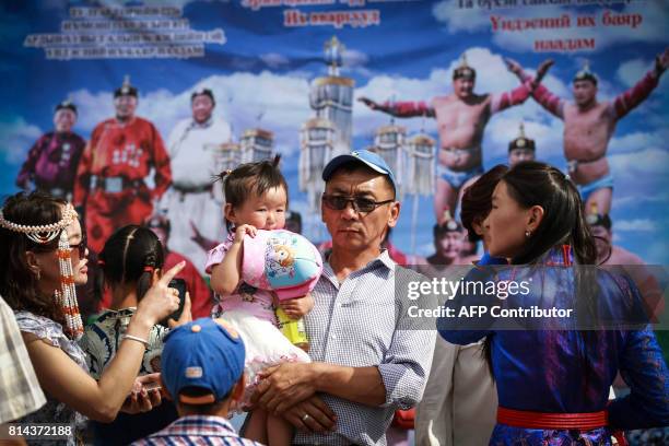 People arrive at the opening ceremony of the traditional Nadaam festival in Ulan Bator on July 11, 2017. The festivities consist of a number of...