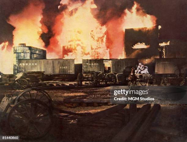 The hero and heroine drive through the burning city of Atlanta in a dramatic scene from the MGM film 'Gone with the Wind'.