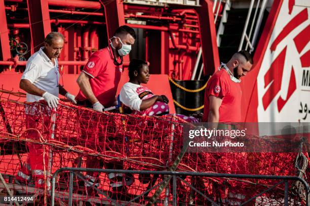 Pregnant woman are helped to disembark from the Italian rescue ship Vos Prudence run by NGO Medecins Sans Frontieres as it arrives in the early...