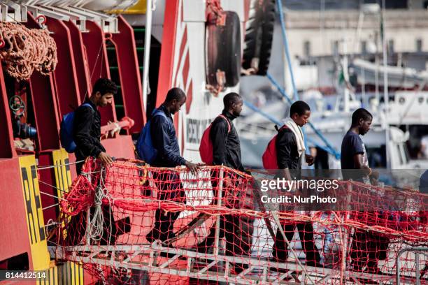 Migrants disembark from the Italian rescue ship Vos Prudence run by NGO Medecins Sans Frontieres as it arrives in the early morning of July 14 in the...