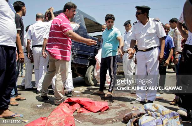 Egyptian policemen inspect the scene of an attack which left five of their colleagues killed in a shooting near Badrasheen, a town some 20 kilometres...