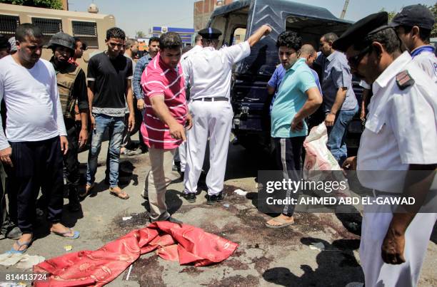 Egyptian policemen inspect the scene of an attack which left five of their colleagues killed in a shooting near Badrasheen, a town some 20 kilometres...