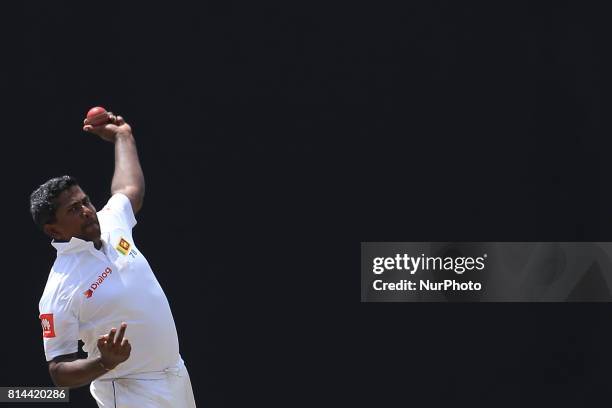 Sri Lankan cricketer Rangana Herath delivers a ball during the first day of the only Test cricket matcth between Sri Lanka and Zimbabwe at R...