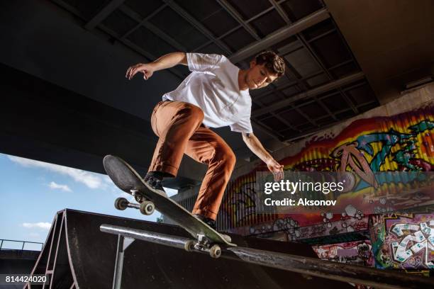 skater jumping on his skate in skatepark - stunts and daredevils stock pictures, royalty-free photos & images
