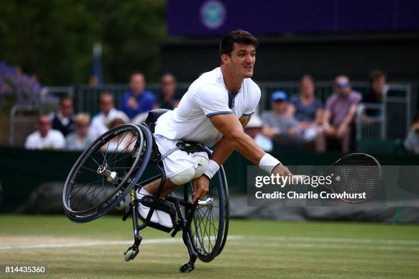 Gustavo Fernandez of Argentina falls over as he reaches for a shot during his Gentlemen's wheel chair tennis semi final against Alfie Hewett of Great...