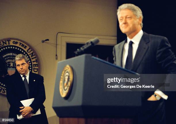 Spokesman Joe Lockhart listens as President Clinton answers a question during a press conference at the White House June 25, 1999.