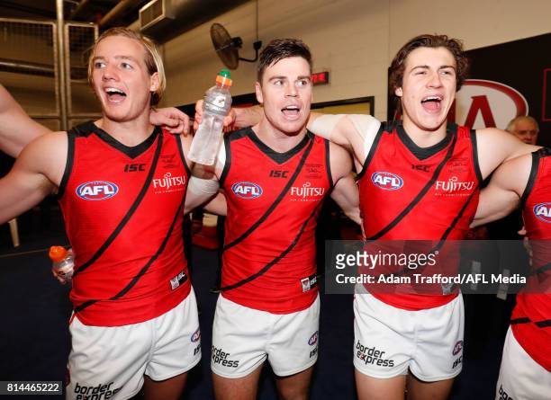 Darcy Parish, Craig Bird and Andrew McGrath of the Bombers sing the team song during the 2017 AFL round 17 match between the St Kilda Saints and the...