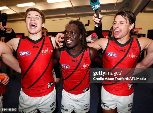 Zach Merrett, Anthony McDonald-Tipungwuti and Mark Baguley of the Bombers sing the team song during the 2017 AFL round 17 match between the St Kilda...