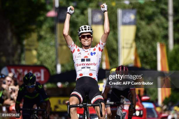 France's Warren Barguil, wearing the best climber's polka dot jersey, celebrates as he crosses the finish line ahead of Colombia's Nairo Quintana and...