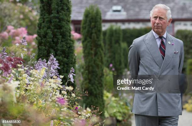 Prince Charles, Prince of Wales takes a tour of the gardens at Plas Cadnant Hidden Gardens during The Prince of Wales' annual summer visit to Wales...