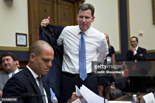 Randy Snook, executive vice president of the Securities Industry and Financial Markets Association , center, puts on his jacket before the start of a...
