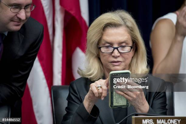 Representative Carolyn Maloney, a Democrat from New York, looks at her mobile phone before the start of a House Financial Services Subcommittee...