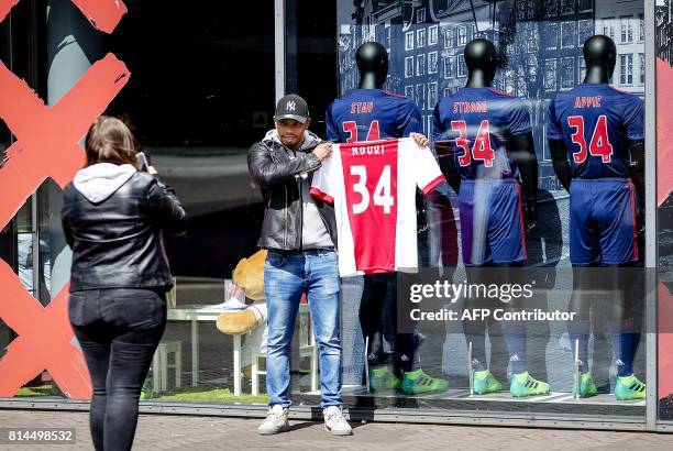 Fan poses with a Abdelhak Nouri football jersey on July 14, 2017 at the fanshop of the ArenA football stadium in Amsterdam. Netherlands midfielder...