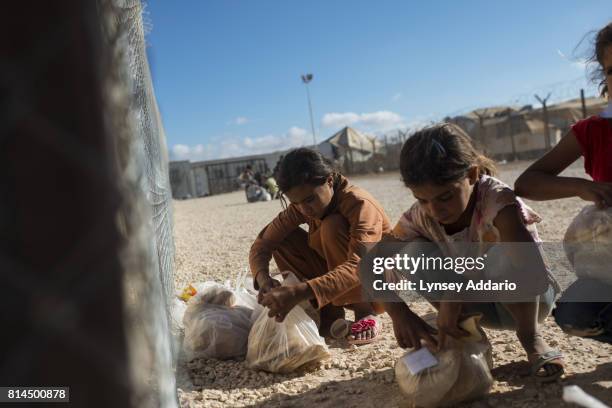 Syrian refugees collect their daily bread rations from a distribution site run by the World Food Program in Zaatari Camp, in Jordan, September 16,...