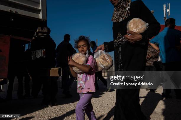 Syrian refugees collect their daily bread rations from a distribution site run by the World Food Program in Zaatari Camp, in Jordan, September 16,...