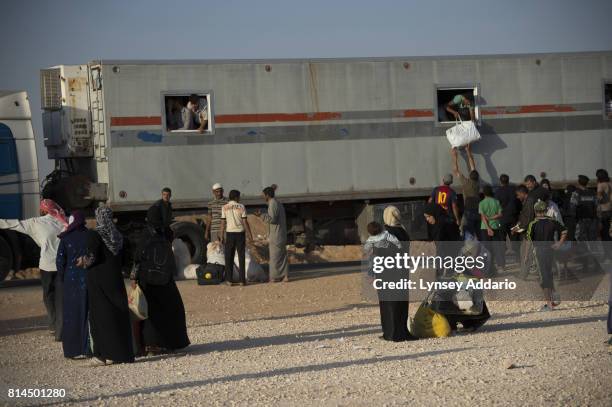 Syrian refugees wait for buses to take them back to the border to cross back into Syria from their current location in Zaatari camp, in Jordan,...