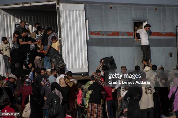 Syrian refugees wait for buses to take them back to the border to cross back into Syria from their current location in Zaatari camp, in Jordan,...