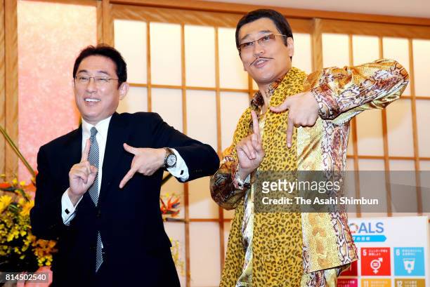 Japanese Foreign Minister Fumio Kishida and Pikotaro pose for photographs during their meeting at the Foreign Ministry on July 12, 2017 in Tokyo,...