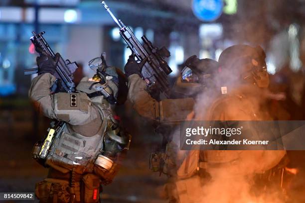 Police Members of a German SWAT hold an MP5 and a HK433 machine gun towards an observed apartment complex, used by protesters from the left-wing...