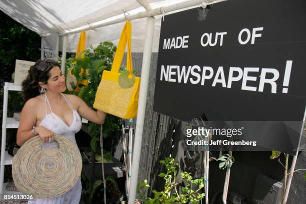 Woman looking at handbags from the made out of newspaper vendor at the Cinco de MiMo Festival.