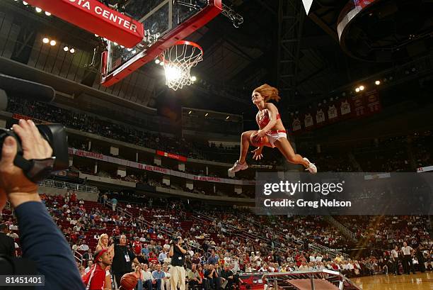 Basketball: Houston Rockets dance team cheerleader making dunk from trampoline during game vs Indiana Pacers, Houston, TX 3/20/2007