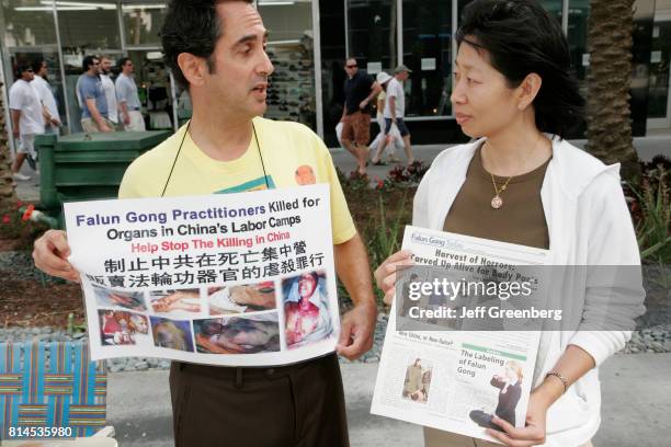 Man and woman protesting meditation exercise and China harvesting organs.