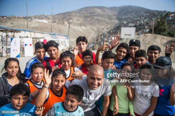 Former French world football champion David Trezeguet poses for a picture with children at San Pablo Mirador community, Chancay district, in the...