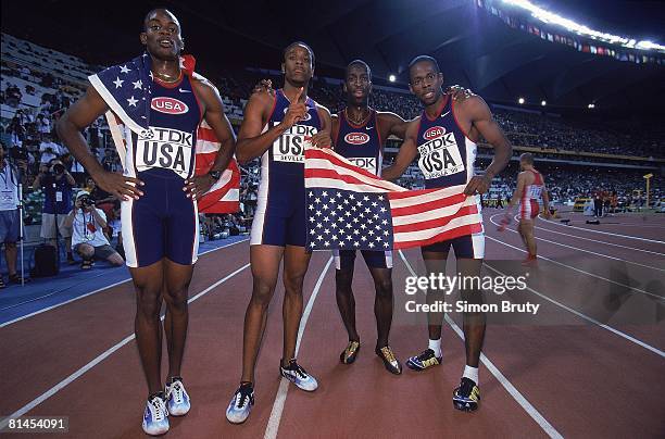 Track: IAAF World Championships, USA Jerome Davis, Antonio Pettigrew, Michael Johnson, and Angelo Davis victorious with USA flag after 4x400M...