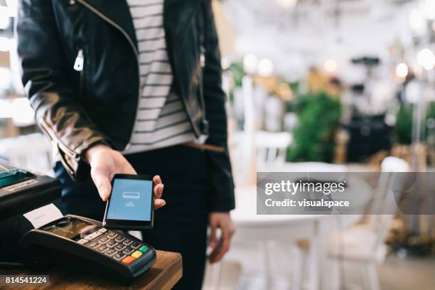 mujer pagando con smartphone. - pago por móvil fotografías e imágenes de stock