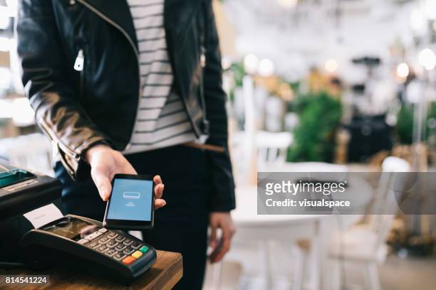 woman paying with smartphone. - paying stock pictures, royalty-free photos & images