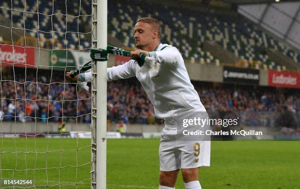 Leigh Griffiths of Celtic ties a Celtic scarf onto a goalpost which sparked crowd disorder after the Champions League second round first leg...