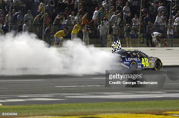 Auto Racing: NASCAR Coca Cola 600, Jimmie Johnson in action, spinning victorious donuts at finish line after winning race, Concord, NC 5/29/2005