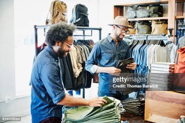 smiling friends shopping in mens clothing boutique - southwest design stock pictures, royalty-free photos & images