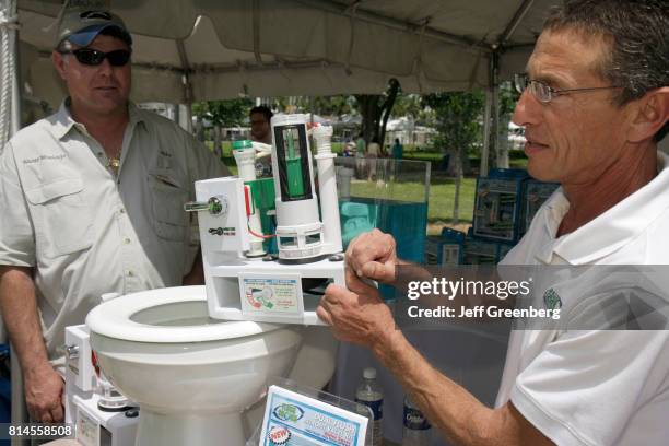 An exhibitor demonstrating a dual flush valve at the Miami Goin' Green event.